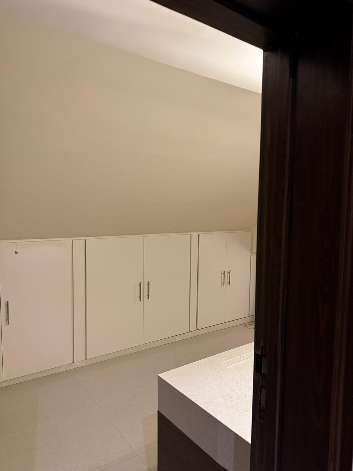 Built-in white storage cabinets fitted under the sloping attic roof at MYG Nathiagali