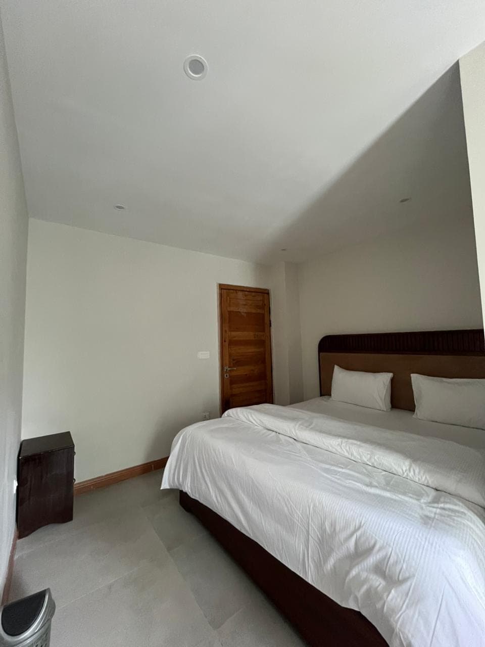 Double bed beside the solid wood entrance door in a hotel room at MYG Nathiagali