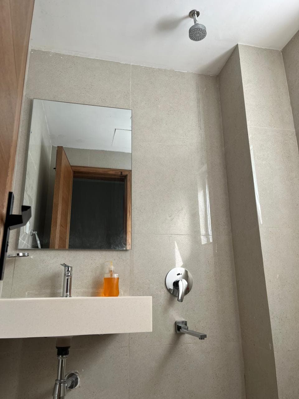En-suite with overhead shower, basin and mirror in a Nathiagali hotel room