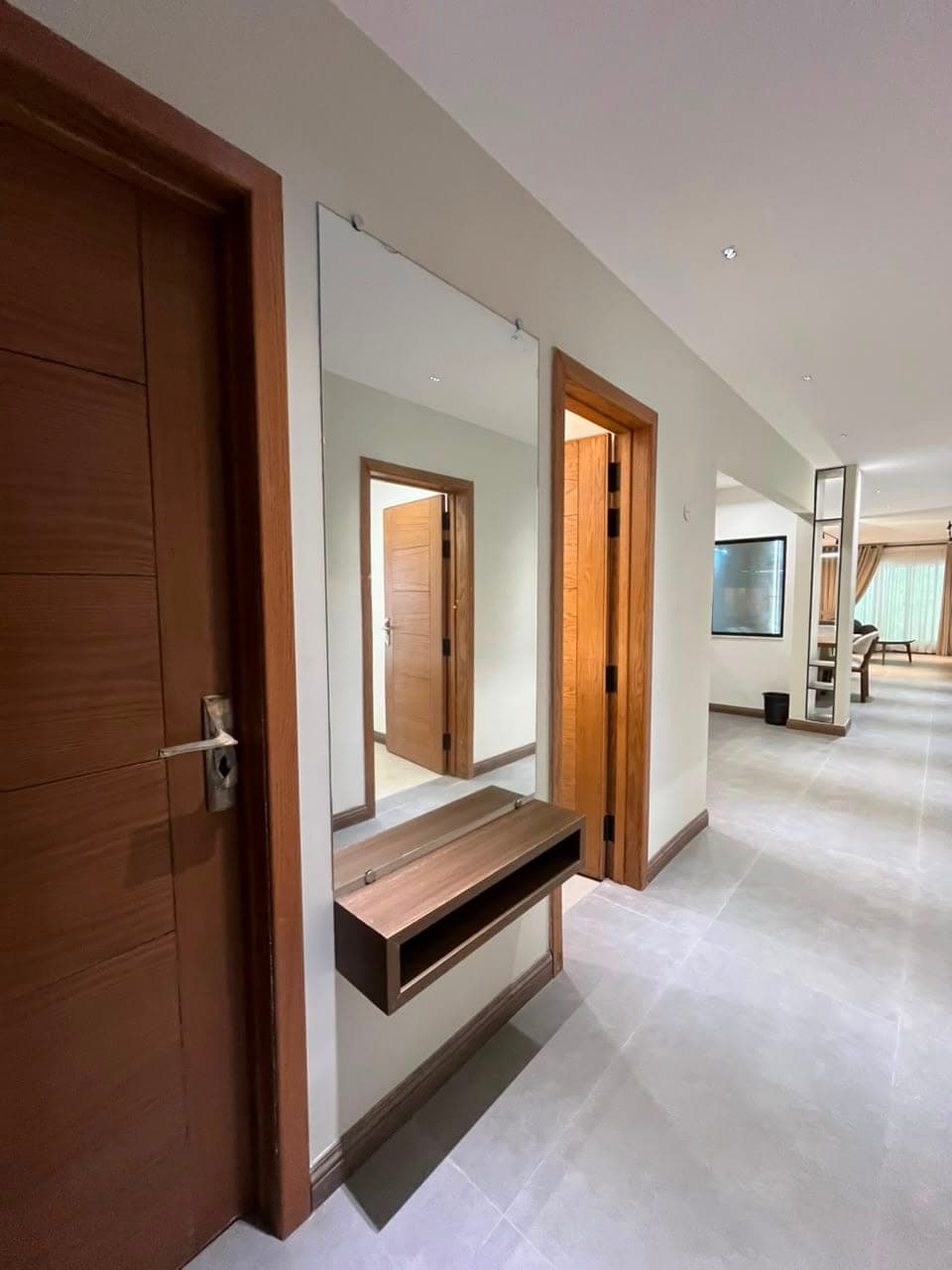 Entrance hall with mirror, floating console and wood doors in a Nathiagali serviced apartment