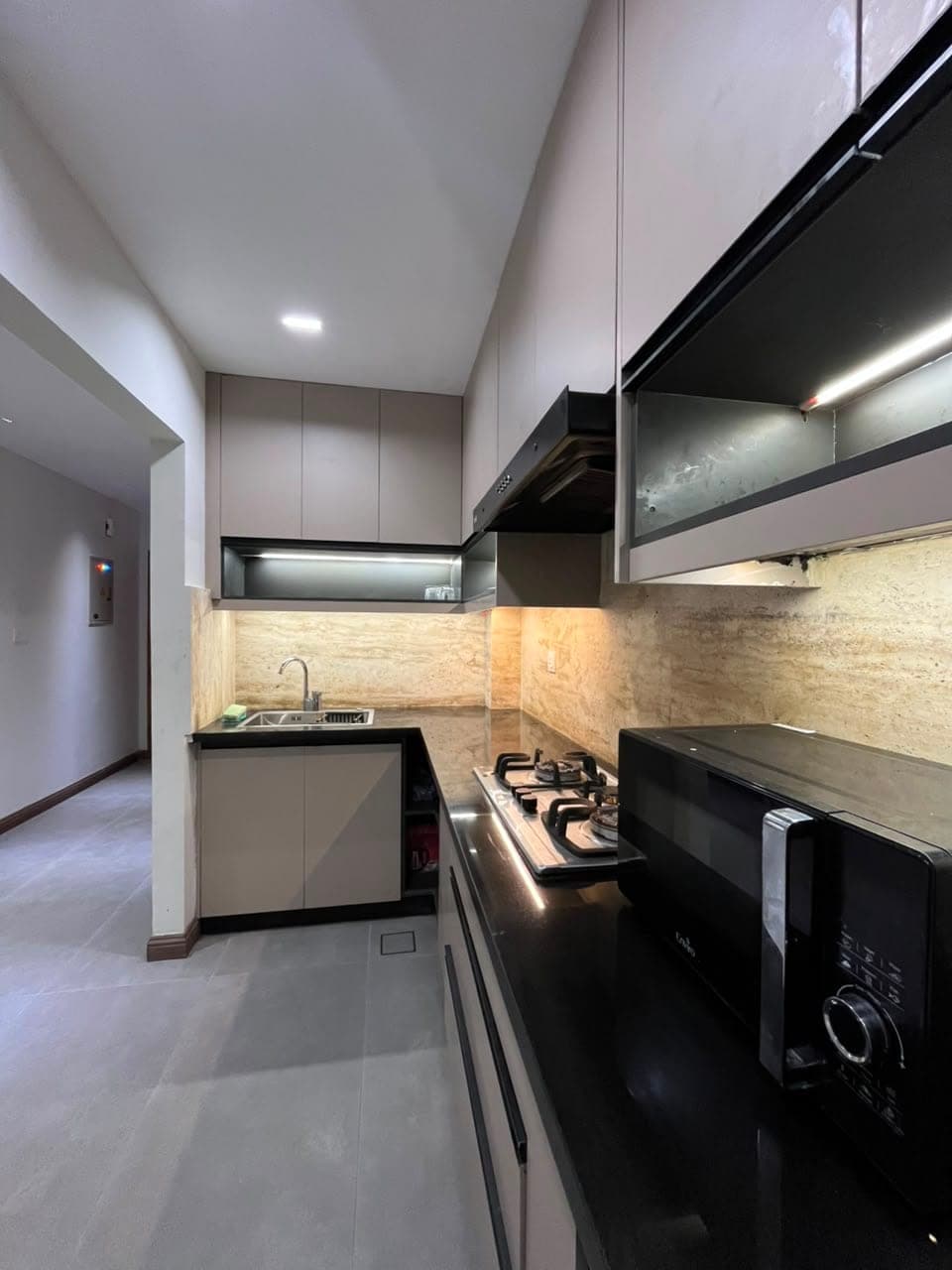 L-shaped kitchen with under-cabinet lighting and microwave in a serviced apartment in Nathiagali