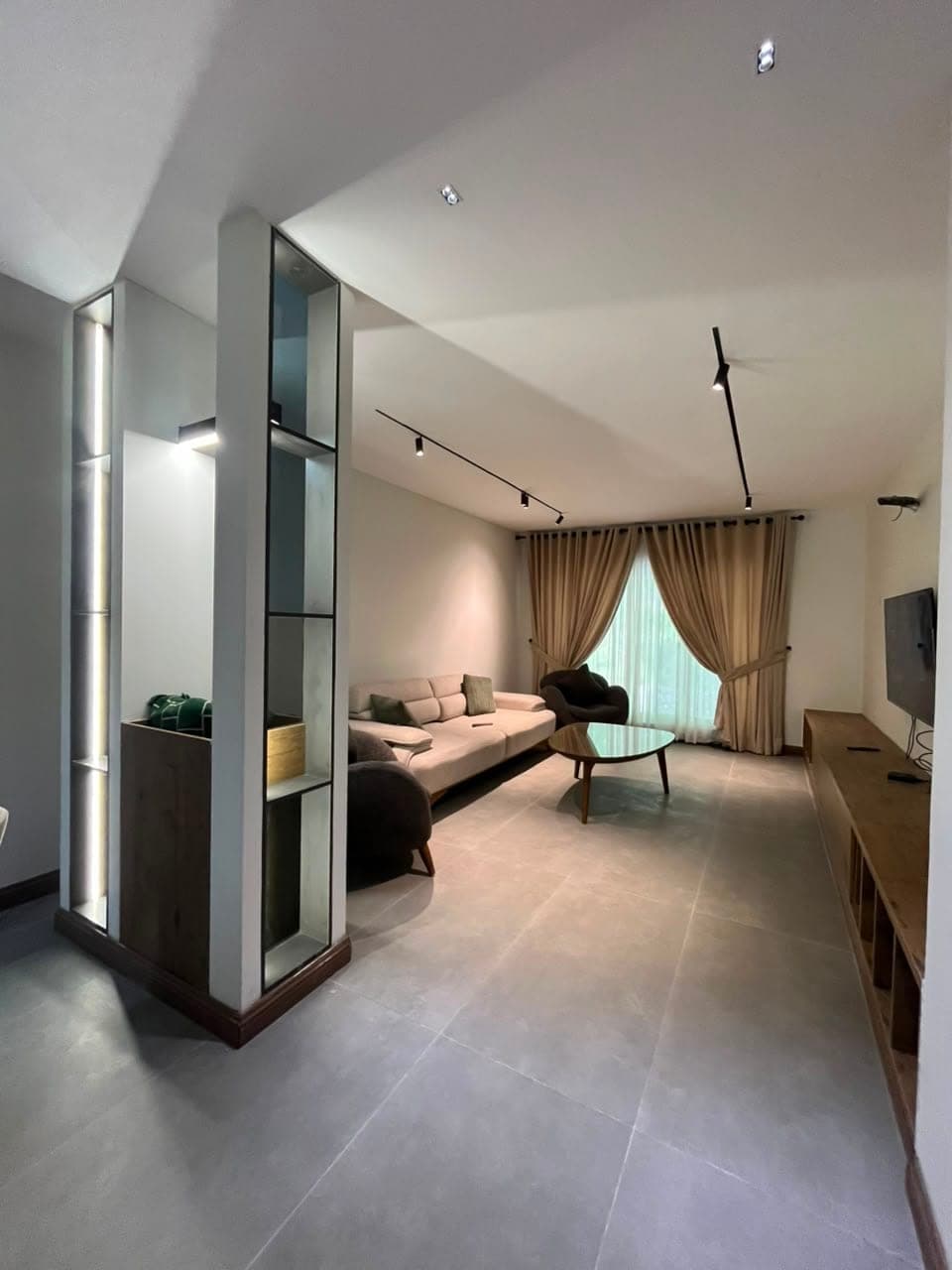 Lounge seen past lit display shelving in the three-bedroom serviced apartment at MYG Nathiagali
