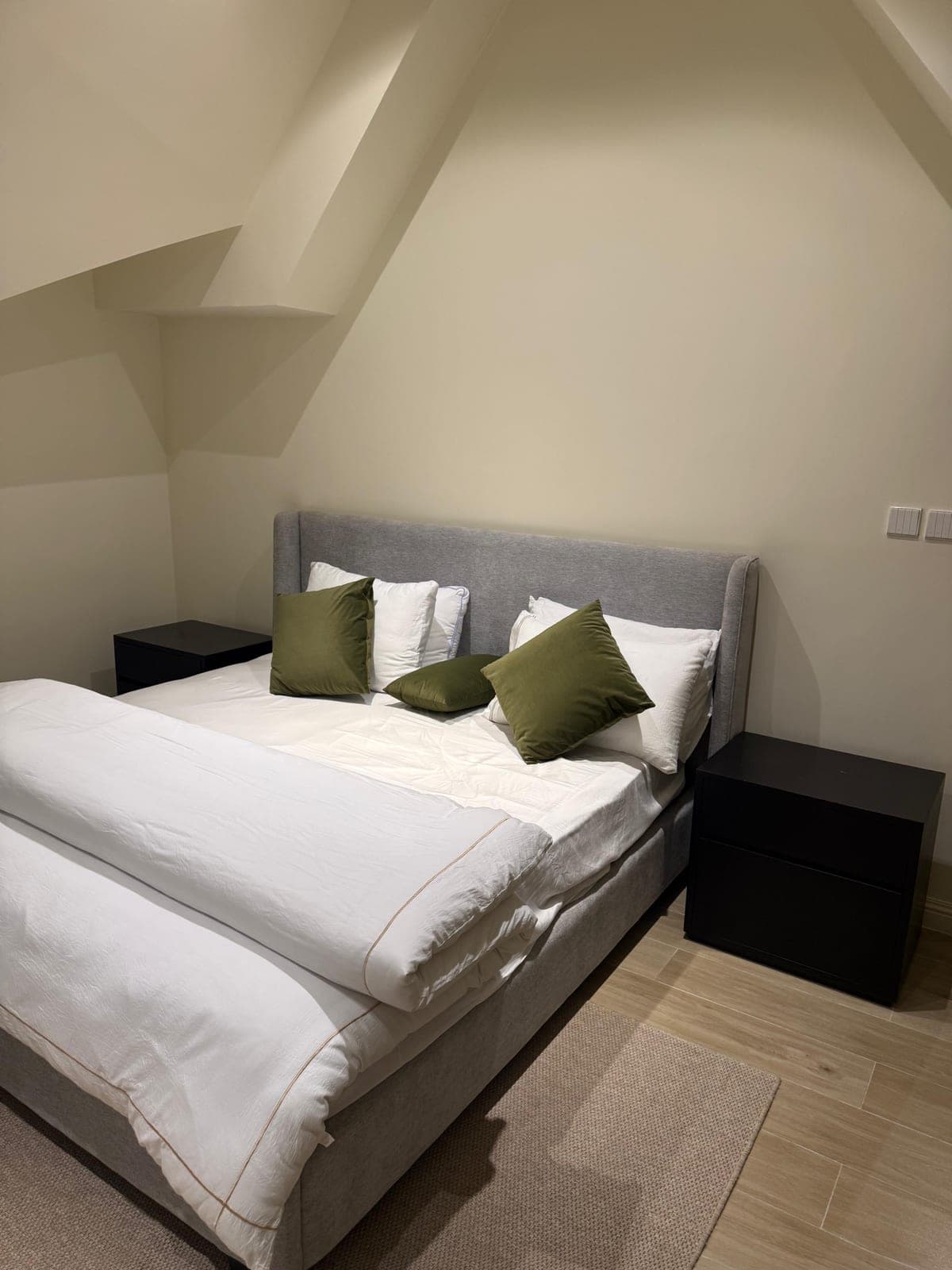 Double bed with upholstered headboard in the one-bedroom attic apartment at MYG Nathiagali