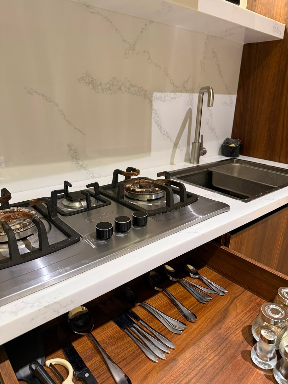 Gas hob, sink and cutlery drawer in the equipped kitchen of a Nathiagali holiday apartment