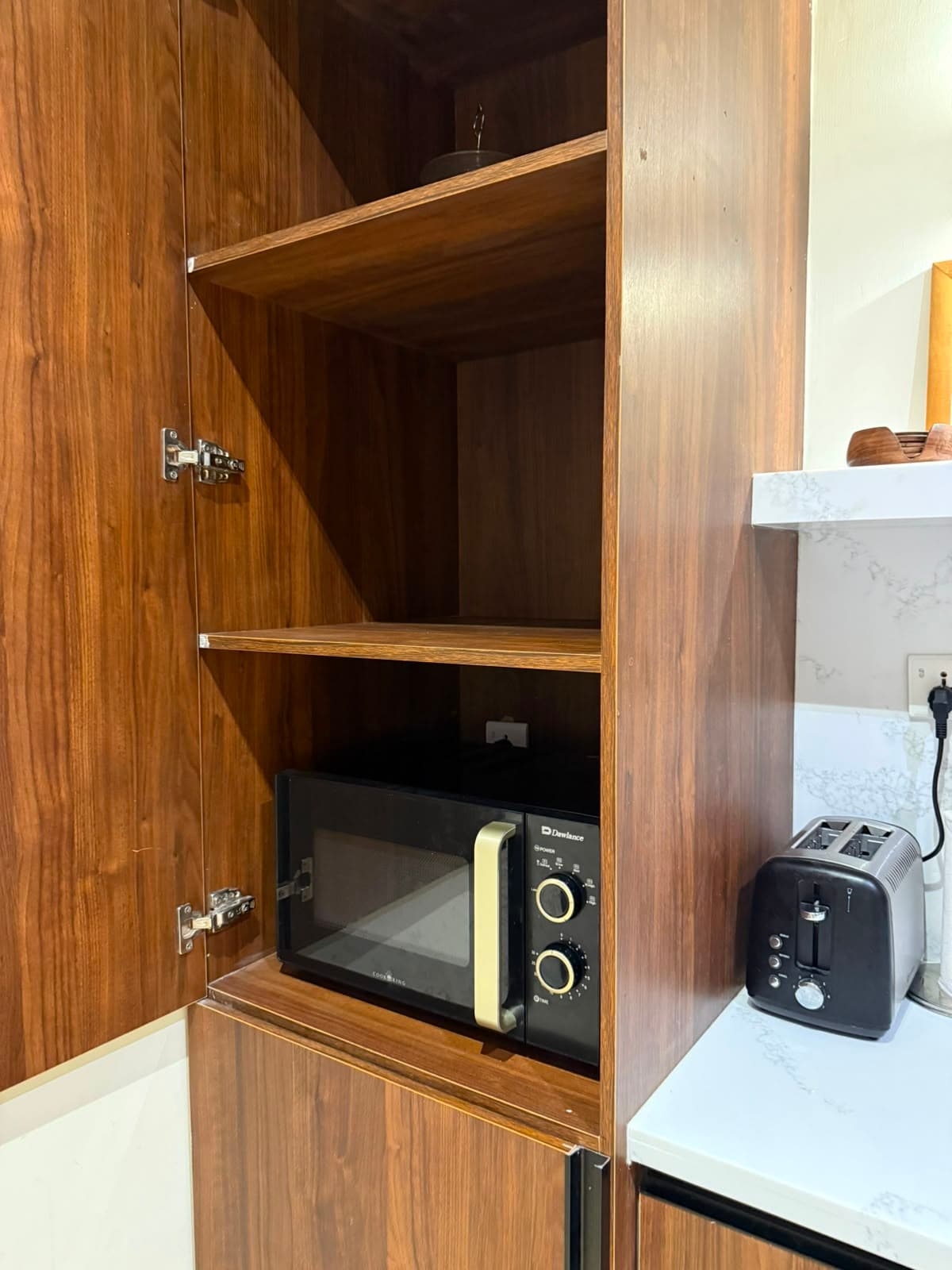 Kitchen pantry with microwave and toaster in the one-bedroom apartment at MYG Nathiagali