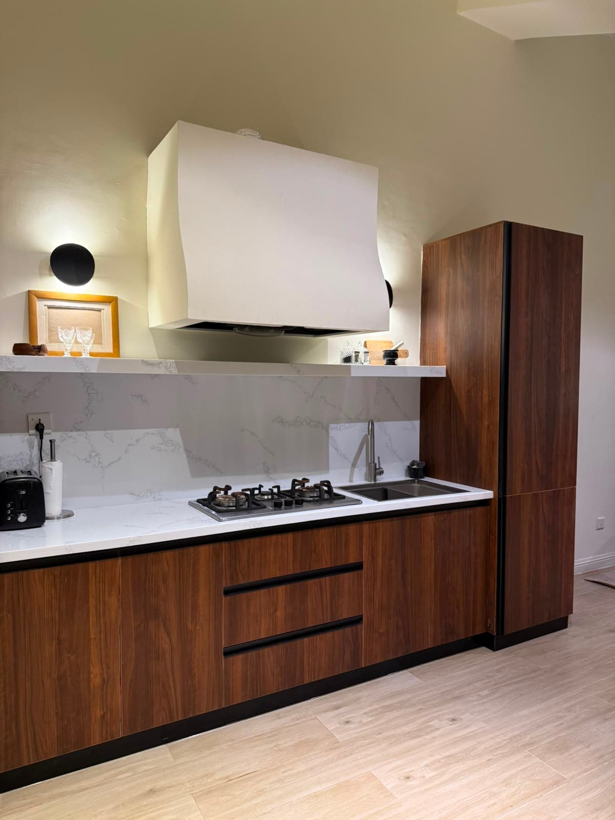 Fitted walnut kitchen with gas hob and marble splashback in the attic apartment in Nathiagali