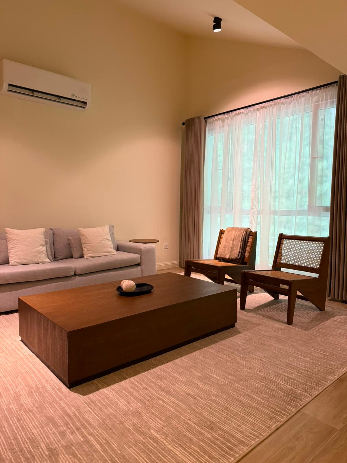 Attic living room with sofa, armchairs and air conditioning in a Nathiagali serviced apartment