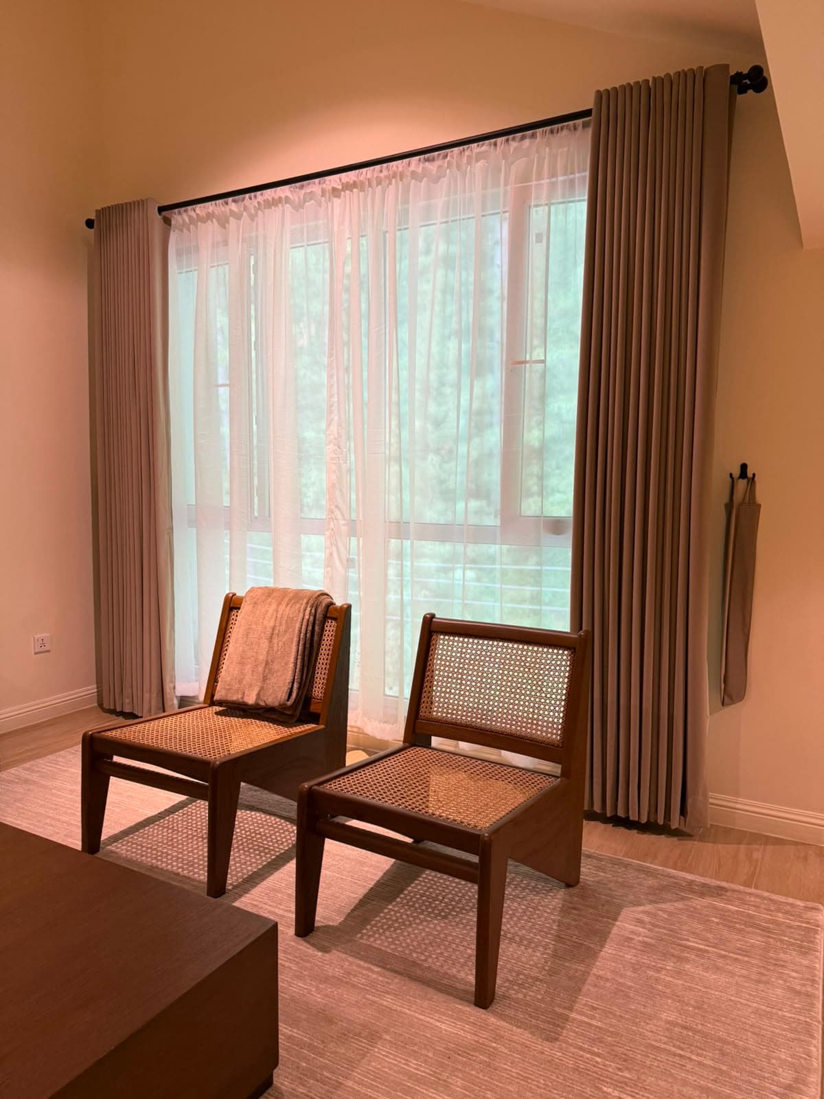 Rattan lounge chairs by the forest-facing window in the attic apartment in Nathiagali