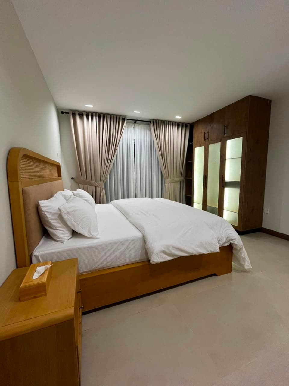 Furnished double bedroom with rattan headboard in a serviced apartment in Nathiagali