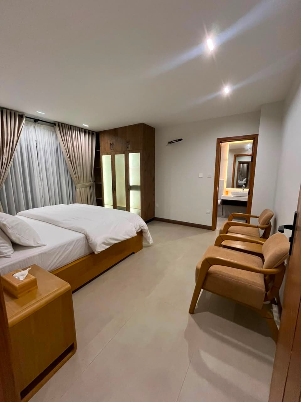 Double bedroom with armchairs and en-suite bathroom in a Nathiagali serviced apartment