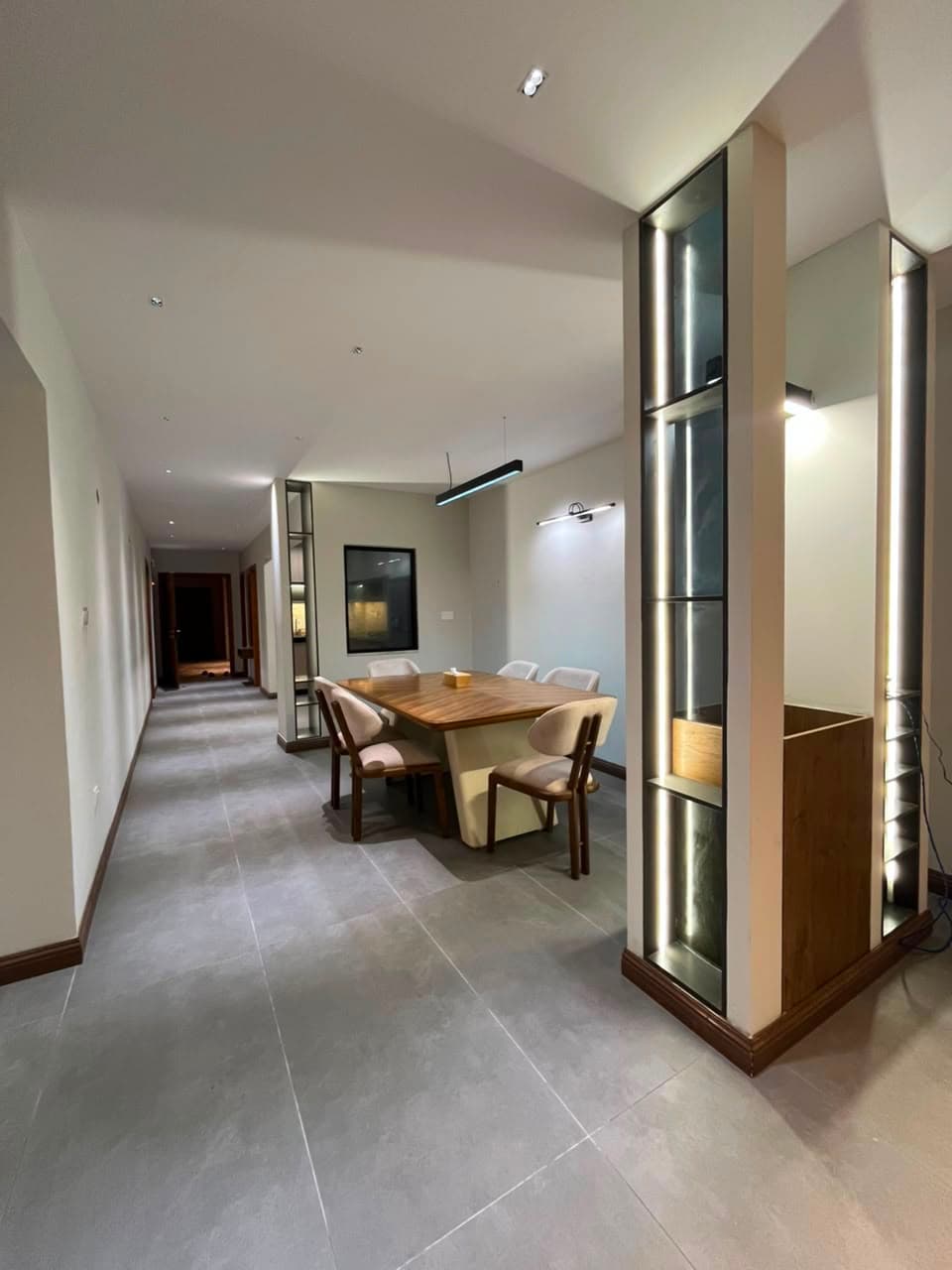 Six-seat dining area with lit display cabinets in the three-bedroom apartment at MYG Nathiagali