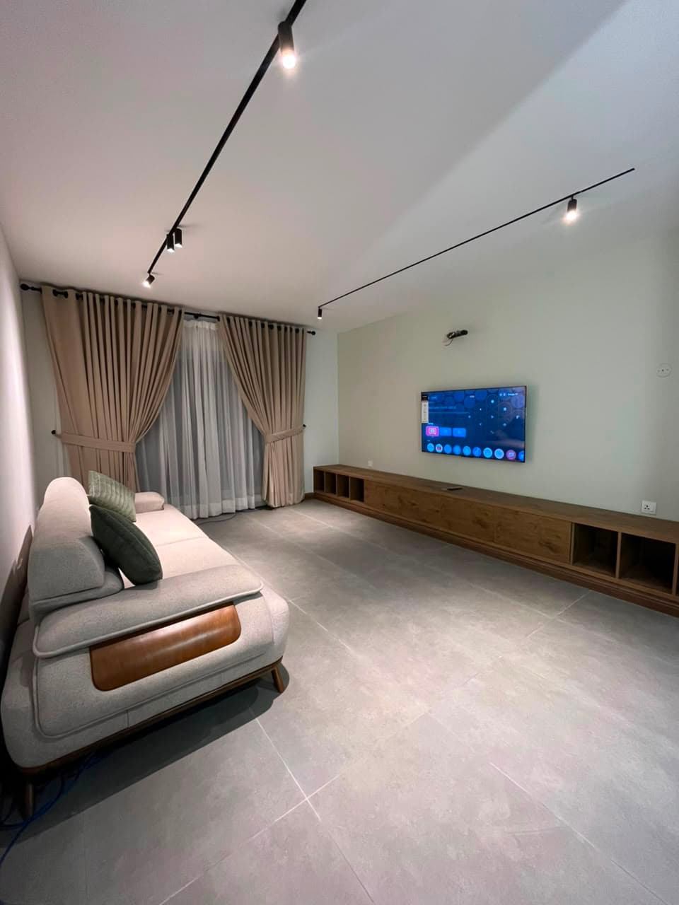 Furnished living room with smart TV and media wall in the three-bedroom serviced apartment at MYG Nathiagali