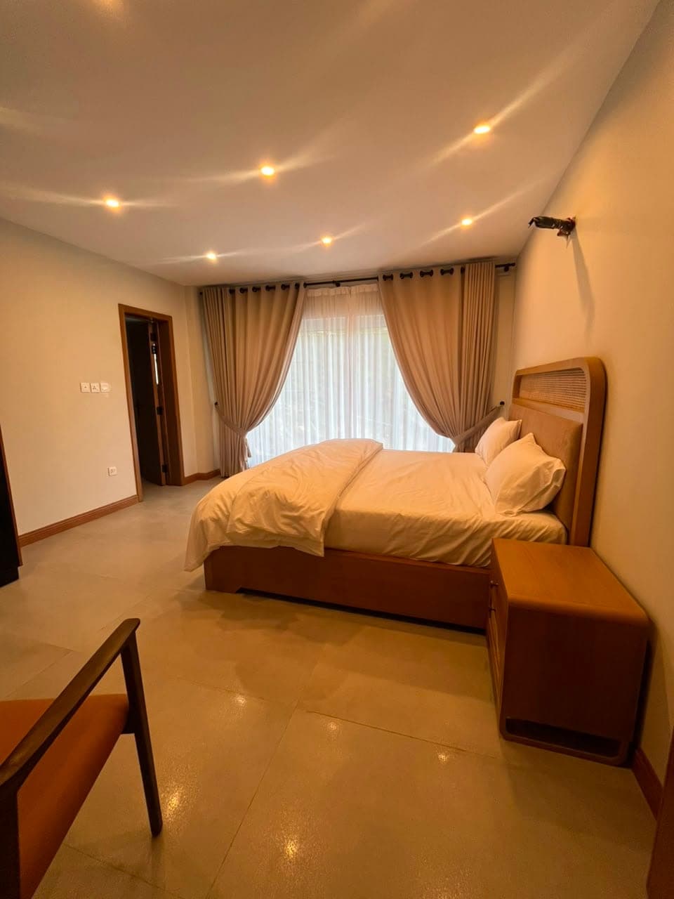 Bedroom with upholstered headboard and draped curtains in the two-bedroom apartment at MYG Nathiagali